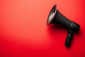 A megaphone resting on a vibrant red background offers opportunities for communication and expression in various settings photo
