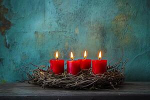Advent wreath with four burning red candles set against a rustic background in France during the Christmas season photo