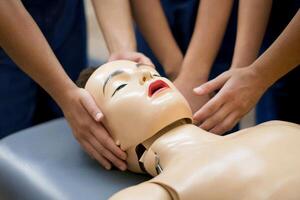 Students practicing CPR chest compression techniques on a medical training dummy in a classroom setting photo