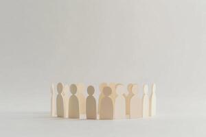 Wooden figures representing people in a circular arrangement on a light background photo