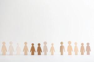 Diversity represented by wooden figures in various skin tones against a plain background photo