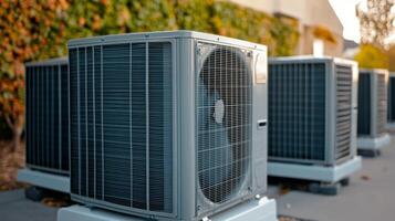 Air conditioning units arranged in a row outside a commercial building in late afternoon light photo