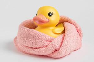 A playful rubber duck nestled in a pink towel during a cozy bath time moment photo