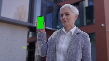 Smiling Senior Woman Showing Chroma Key Smartphone with OK Sign video
