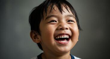 Adorable young Asian boy laughing joyfully with a happy expression photo