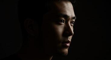 Dramatic portrait of a young Asian man looking off into the distance photo