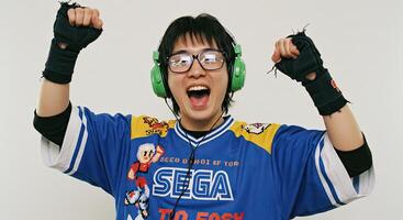 Ecstatic Asian gamer celebrates victory with raised fists and retro jersey photo