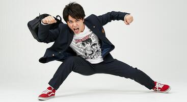 Energetic Asian man in school uniform striking a dynamic pose mid-air photo
