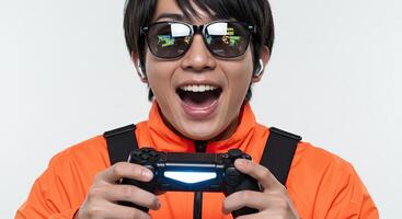 Excited Asian man enjoying game reflected in glasses indoors studio photo