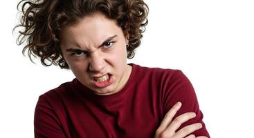 Furious young male glaring with anger and crossed arms on white backdrop photo