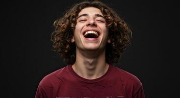 Man with curly hair laughing joyfully against a dark gray background photo