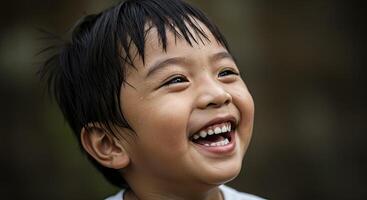 Smiling asian boy looking up with joy and happiness in outdoor environment photo