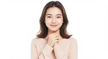 Smiling young Asian woman with hands clasped in anticipation and hope photo