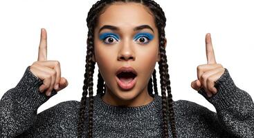 Surprised young woman with blue eyeshadow pointing upwards excitedly photo