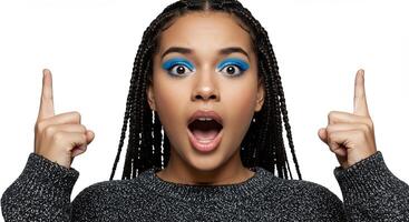Surprised young woman with vibrant blue eyeshadow pointing upwards photo