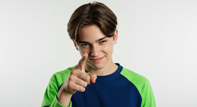 Teenager pointing at the camera with a sly grin, confident expression photo