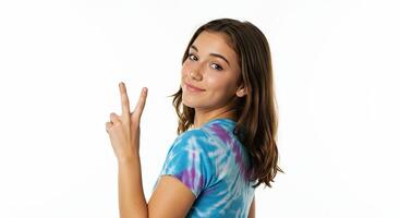 Young woman smiling and showing peace sign with tie dye shirt on white photo