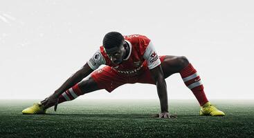 Soccer player stretching on a green field in a dynamic and athletic pose photo