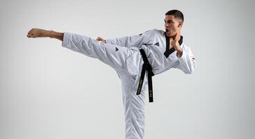Taekwondo athlete performs a dynamic side kick in action studio shot photo