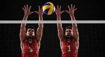 Two male volleyball players blocking the ball over the net on a black background photo