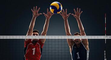 Two male volleyball players jumping and blocking the ball at the net in action photo