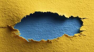 Torn yellow paper with a jagged edge revealing a vibrant blue background underneath, creating a striking contrast and an engaging visual element for creative projects photo