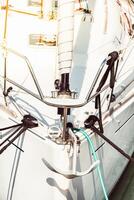 Sailboat anchor detail with ropes and white hull, suitable for background photo