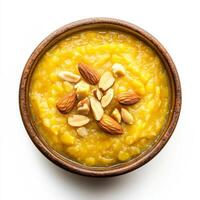 A bowl of moong dal halwa, with a sweet pudding made from mung beans, milk, and sugar, garnished with nuts and cardamom, isolated photo