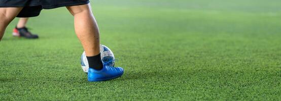 Soccer players in action on green grass field focusing on their legs and ball during game, showing movement and sports energy in close up view photo