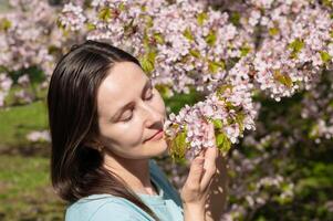 Smiling woman surrounded by blooming trees on a warm spring day photo