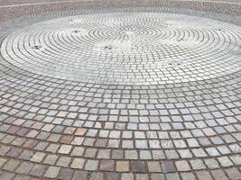 Circular stone pavement with intricate pattern and water fountains photo