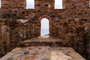Ancient Stone Fortress Gateway Overlooking a Tranquil Ocean Horizon photo