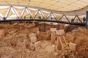 Gobeklitepe ancient site in Urfa, Turkey with stone monoliths arranged in a circular pattern, conveying the mysteries of early human construction and culture. photo