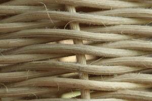 Macro shot of woven rattan texture, showing detailed natural fibers and fine dust particles in a tight interlaced pattern photo