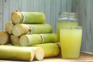 Fresh sugar cane stalks neatly arranged on a table with a natural background photo