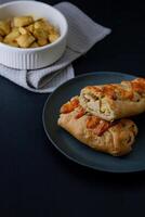 Gourmet chiken bake in dark food style, highlighting its golden crust and creamy filling in a sophisticated presentation. photo
