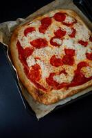 a pizza on a tray with a piece of paper photo