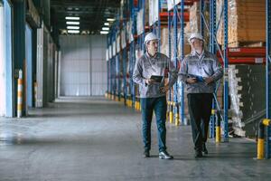 Two men in hard hats walking in a warehouse photo