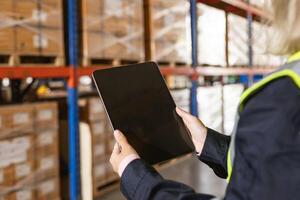 closeup warehouse worker using modern tablet computer wireless digital technology device in logistic photo