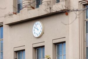 high school facade building with clock at the center in japan traditional style visible in cartoon photo