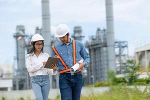 Asian engineer and asian female engineer working together in the field with a tablet photo