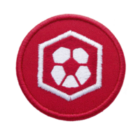 This shows red embroidered patch featuring white hexagonal soccer ball design, symbolizing sports or team spirit. patch is circular and has textured fabric appearance png