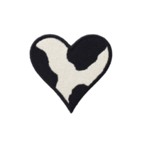 Heart shaped patch with black and white cow print pattern, resembling playful and unique design. texture appears soft and embroidered, adding tactile element png