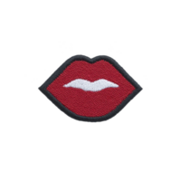 Red embroidered patch in shape of lips with black outline and white detailing, set against plain background. design is bold and playful, ideal for fashion embellishments png