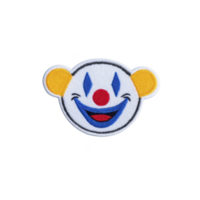 Colorful embroidered patch features cheerful clown face with big smile, red nose, and blue eyes, set against transparency background. clown has yellow ears, adding playful touch png