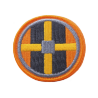 Round embroidered patch features bold design with central cross pattern in yellow and gray, set against transparency background, and bordered by orange edge png