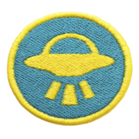 Round embroidered patch features yellow UFO design on blue background, with yellow border. UFO emits beams, creating playful and mysterious vibe png