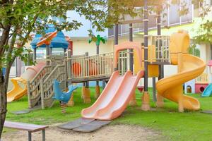 A colorful playground with a slide and swings photo