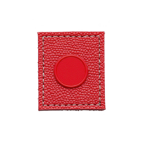 A This shows red textured leather patch with circular embossed design in center, featuring visible stitching around edges. vibrant color and detailed texture create striking visual effect png