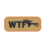 A This features rectangular embroidered patch with letters WTF and rifle graphic. patch has beige background with orange border, conveying humorous or edgy tone png